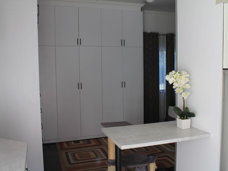 A bedroom featuring floor-to-ceiling built-in cupboards with a clean, modern white finish.
