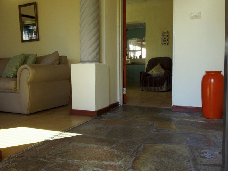 Entrance area featuring natural stone flooring and a decorative column, providing access to the adjacent living space and interior rooms.