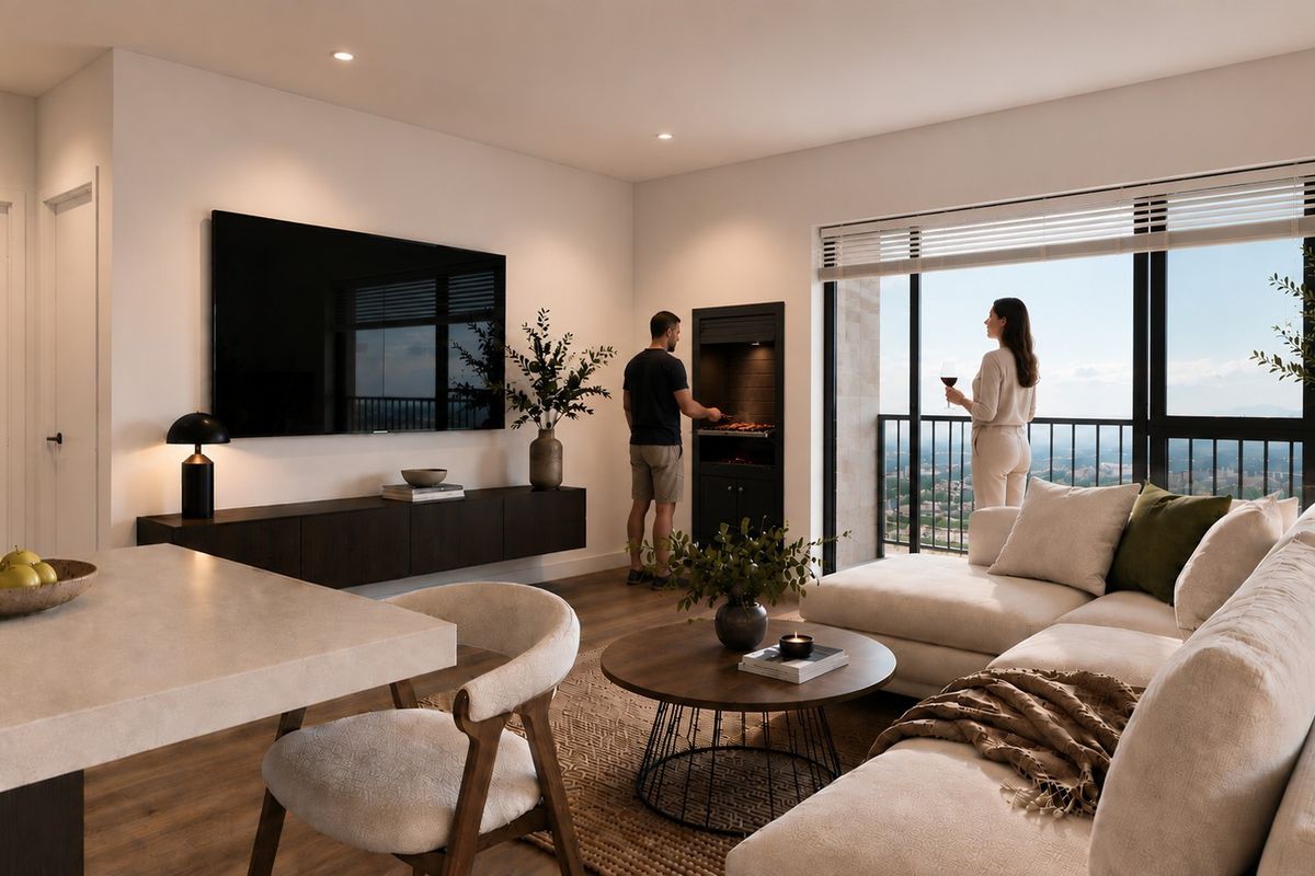 Modern open-plan living area featuring a built-in braai, sleek laminate flooring, and large sliding doors leading to a balcony with expansive views.