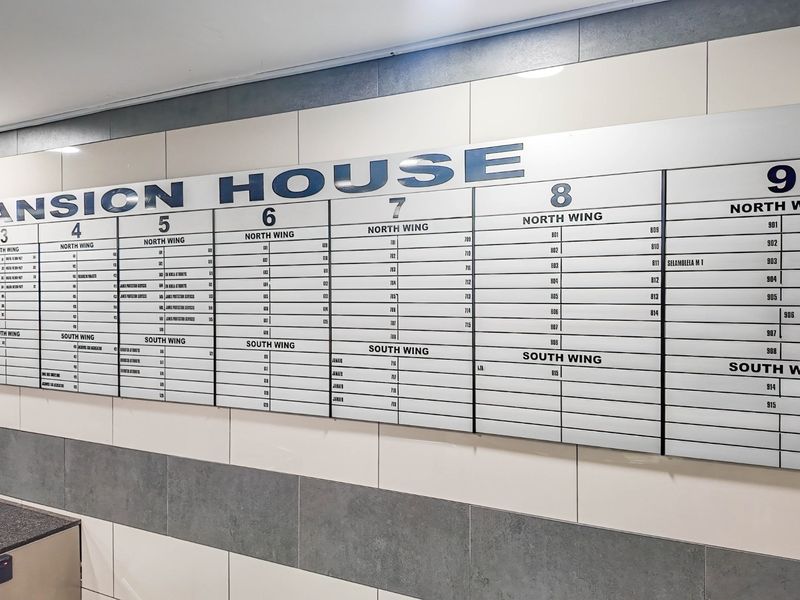 A clear and well-maintained building directory board located in the entrance area of Mansion House, displaying office suite numbers and wing locations.