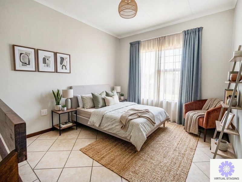 A well-maintained bedroom featuring neutral wall tones, tiled flooring, and large windows with curtains, providing a bright and comfortable living space.