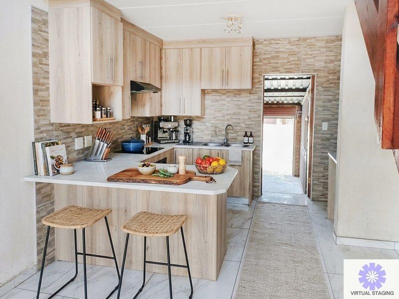 Modern kitchen featuring light wood cabinetry, stone countertops, integrated hob and extractor, and stylish tiled backsplash with direct access to the rear exterior.