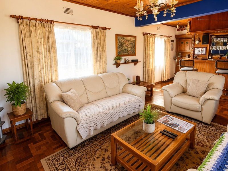 A cozy living room featuring warm parquet flooring, a timber ceiling, and a built-in bar area, creating a traditional and inviting atmosphere.