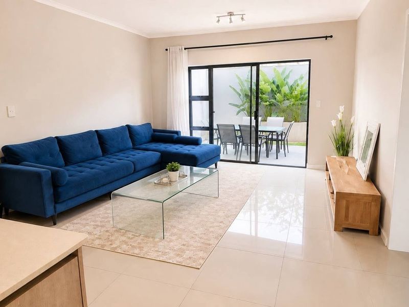 Bright open-plan living area featuring polished tile flooring and large sliding glass doors that provide seamless access to the outdoor patio space.