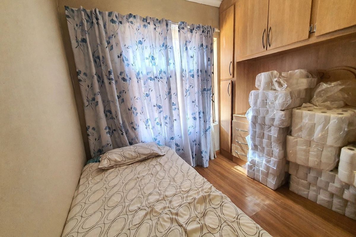 A bedroom featuring laminate flooring and built-in wooden cupboards, providing functional storage space.