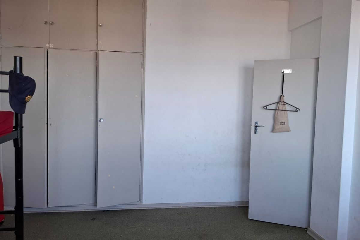 A bedroom featuring built-in cupboards and carpeted flooring, requiring cosmetic updates to improve its overall condition and appeal.
