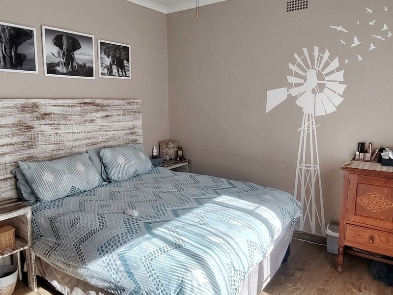 A cozy bedroom featuring laminate flooring and neutral wall tones, providing a comfortable and functional sleeping space.