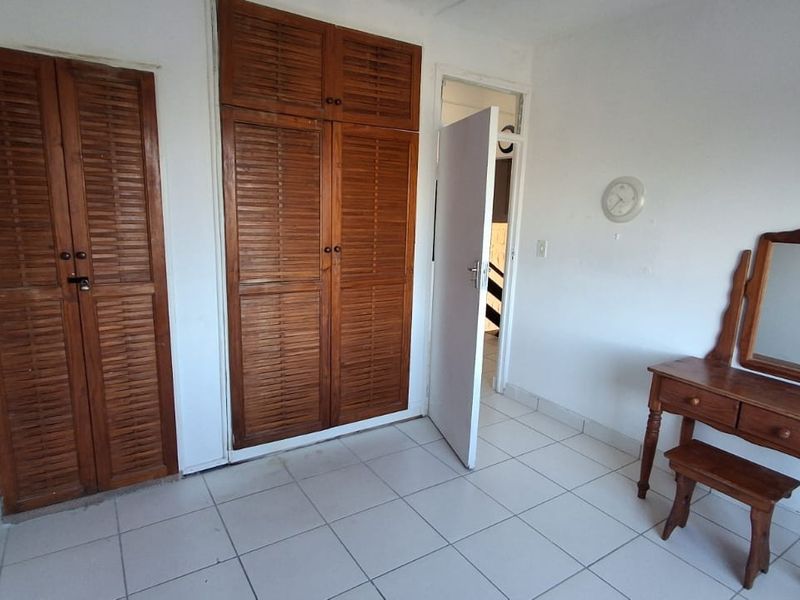 Bedroom featuring built-in wooden louvered closets and ceramic tile flooring.