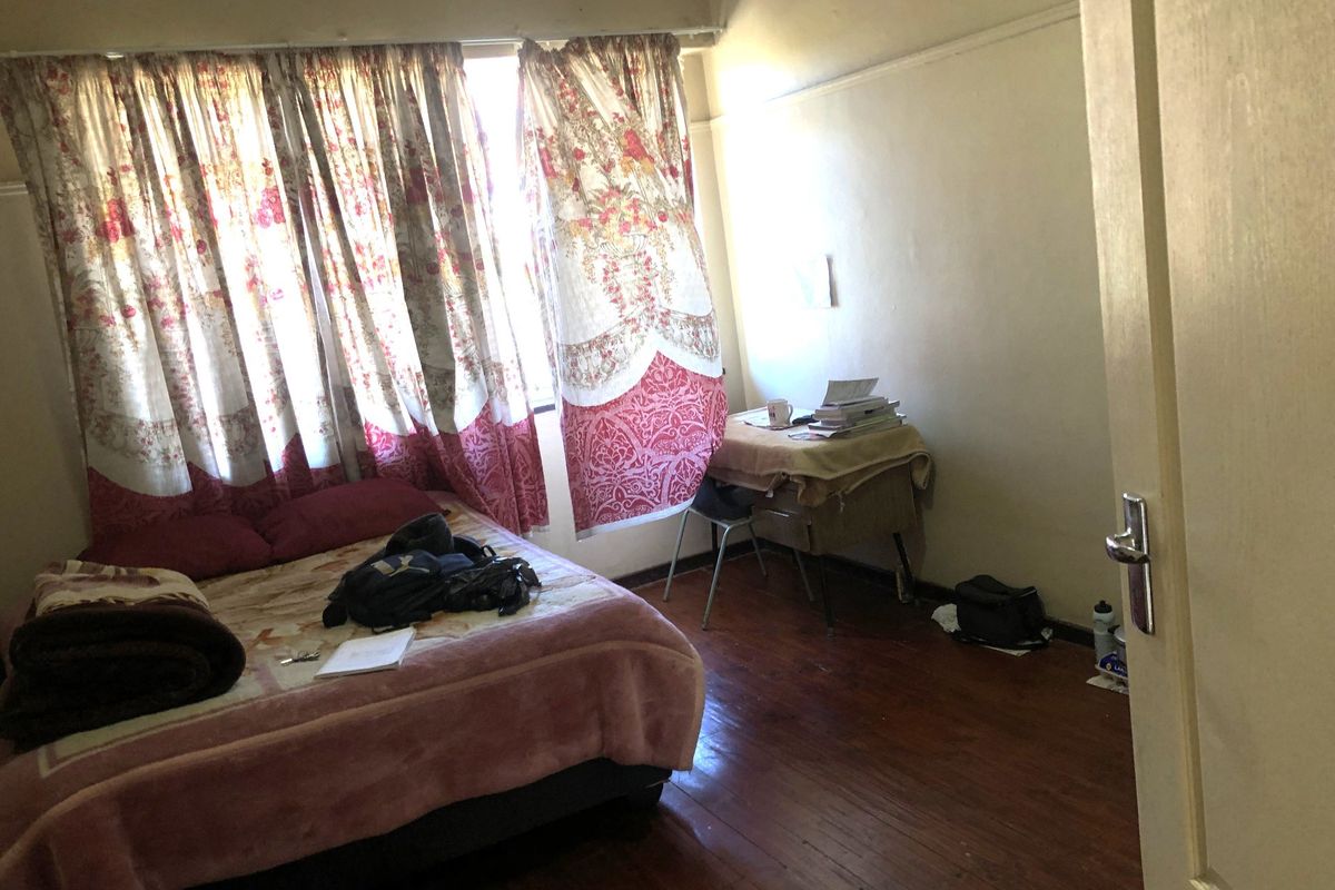 A bedroom featuring original hardwood flooring and a picture rail, requiring cosmetic updates to improve its overall condition and appeal.