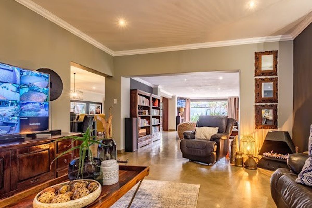 Spacious living area featuring polished concrete floors, recessed downlighting, crown molding, and a built-in fireplace, creating a warm and inviting atmosphere.