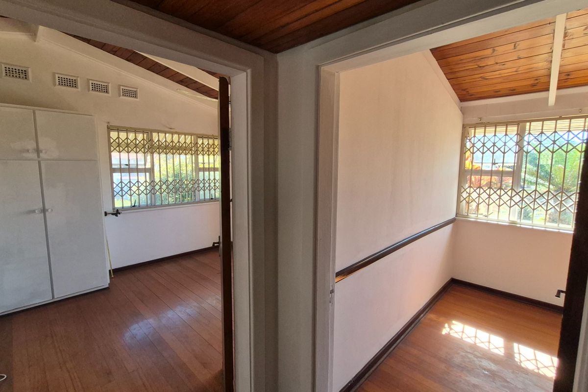Two adjacent bedrooms featuring timber ceilings, hardwood flooring, and built-in cupboards, secured with metal window gates.