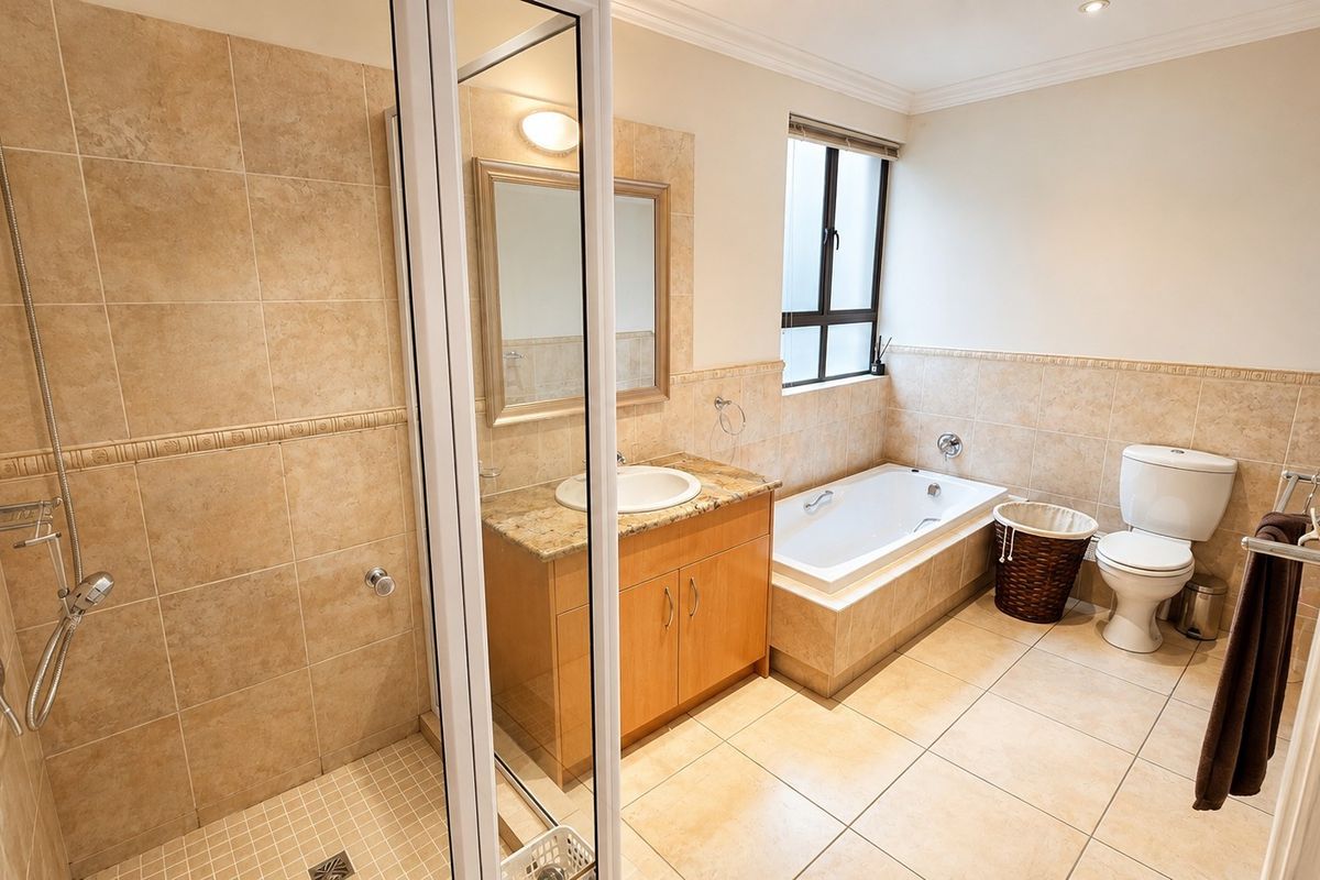 A well-maintained bathroom featuring a separate shower, built-in bathtub, vanity with granite countertop, and neutral tiled finishes.
