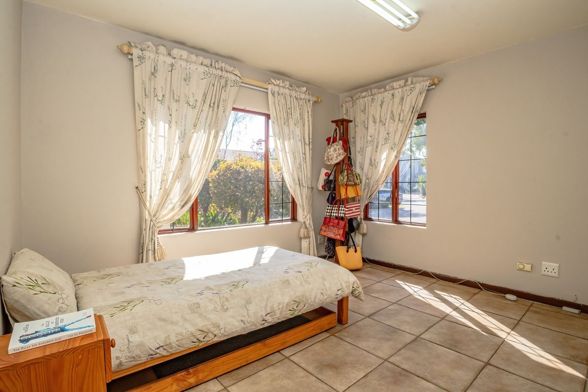 A bedroom featuring tiled flooring and large windows that provide ample natural light.