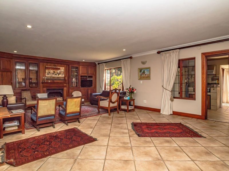 Spacious living room featuring built-in wooden cabinetry, a fireplace, tiled flooring, and recessed lighting, with direct access to adjacent rooms.