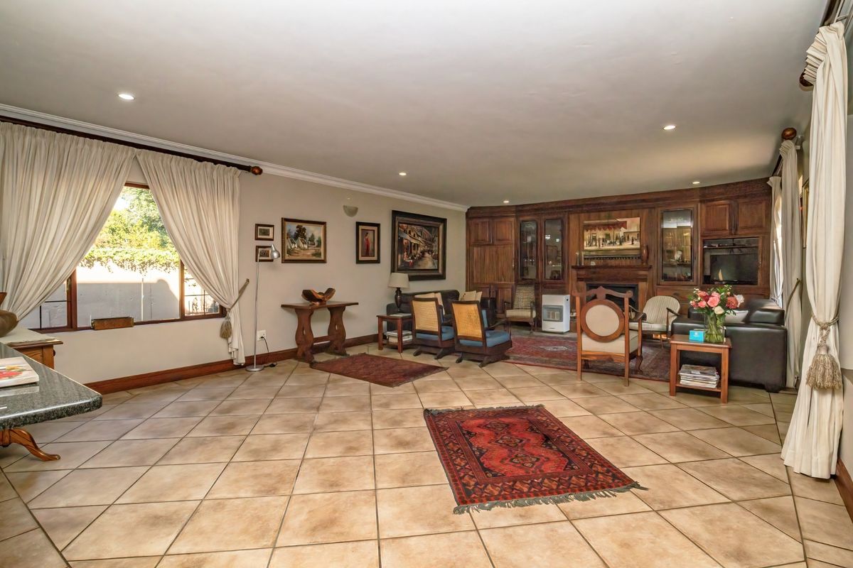 Spacious living room featuring large format floor tiles, recessed lighting, and extensive built-in wooden cabinetry with an integrated fireplace.
