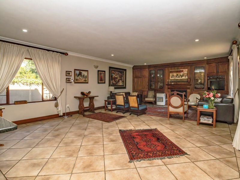 Spacious living room featuring large format floor tiles, recessed lighting, and extensive built-in wooden cabinetry with an integrated fireplace.