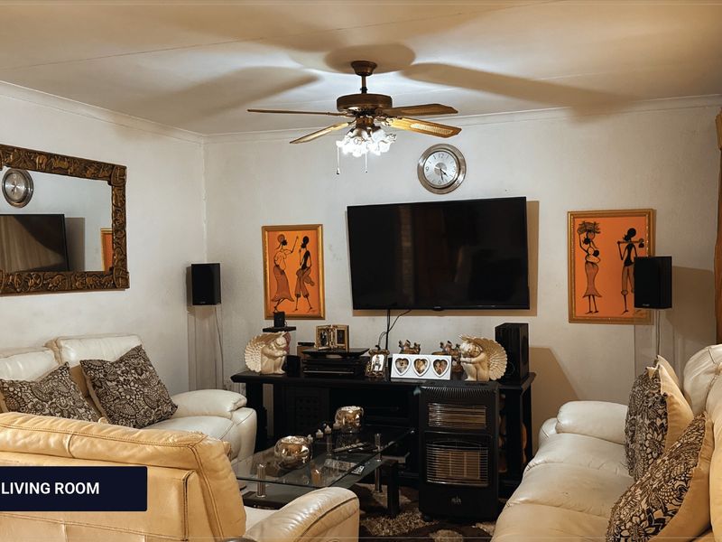 A comfortable living room featuring a ceiling fan and coving, providing a functional space for relaxation and entertainment.
