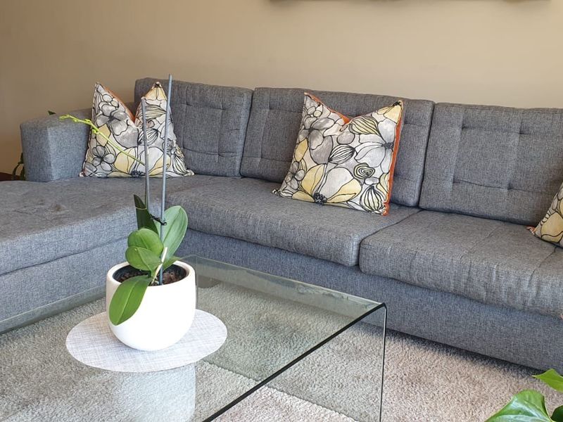 A comfortable living room area featuring neutral wall tones and tiled flooring, providing a clean and functional space for relaxation.