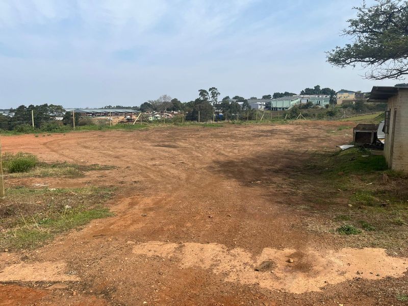 A view of the vacant agricultural land featuring open terrain, wire perimeter fencing, and a small existing outbuilding structure.