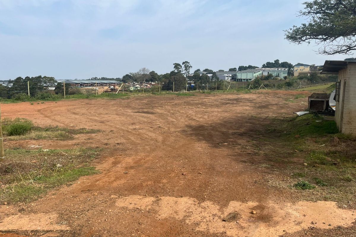 A view of the vacant agricultural land featuring open terrain, wire perimeter fencing, and a small existing outbuilding structure.