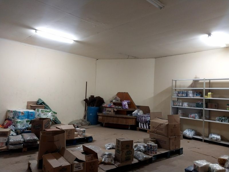 A functional utility or storage space featuring industrial metal shelving and overhead fluorescent lighting, suitable for retail inventory management.