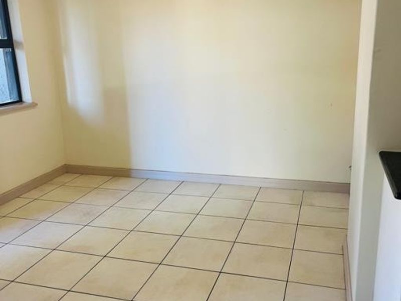 An empty living area featuring ceramic floor tiles and neutral wall finishes, ready for personalization.