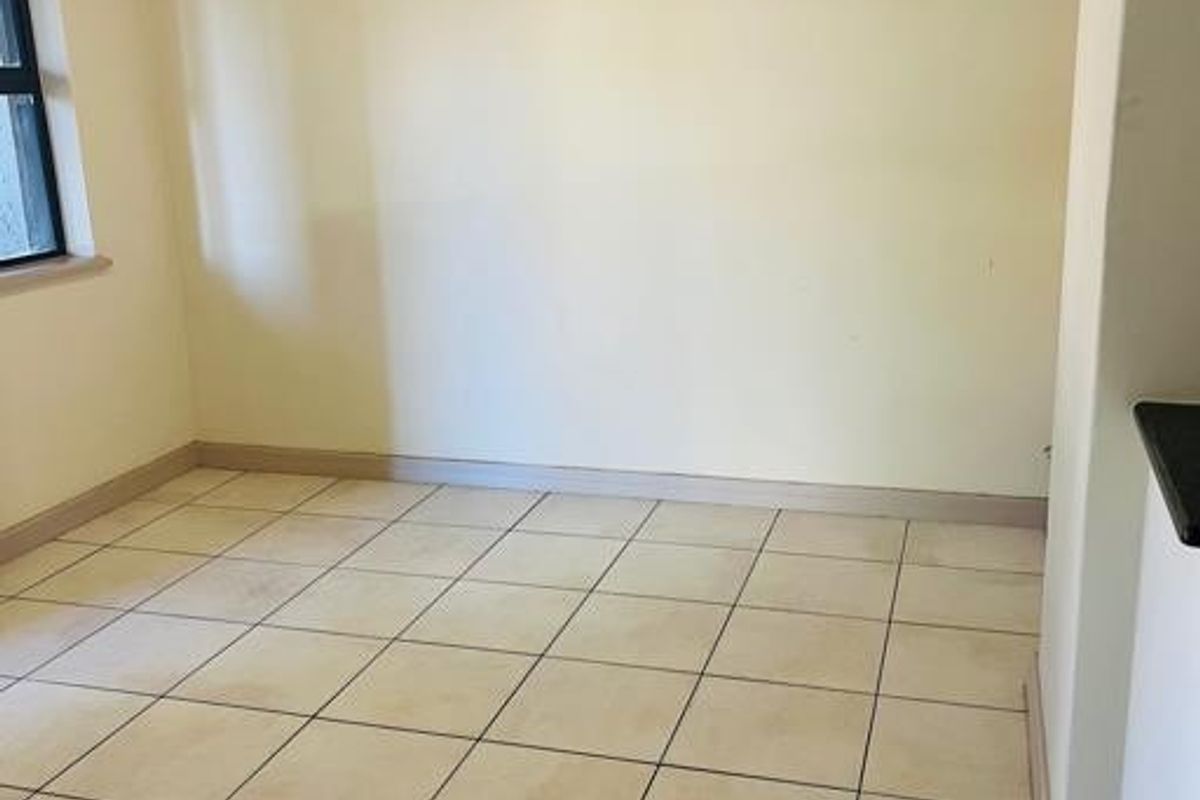 An empty living area featuring ceramic floor tiles and neutral wall finishes, ready for personalization.