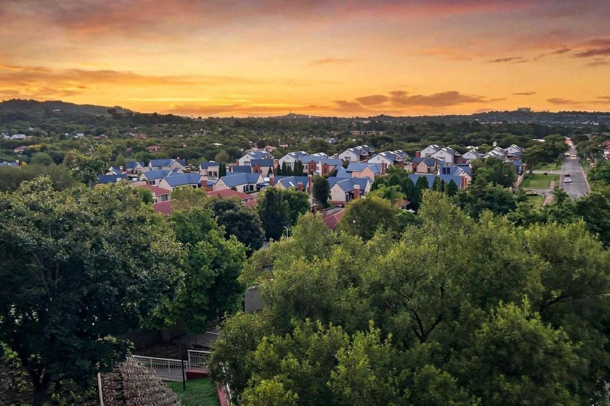An elevated aerial view of the surrounding residential estate and neighbourhood at sunset.