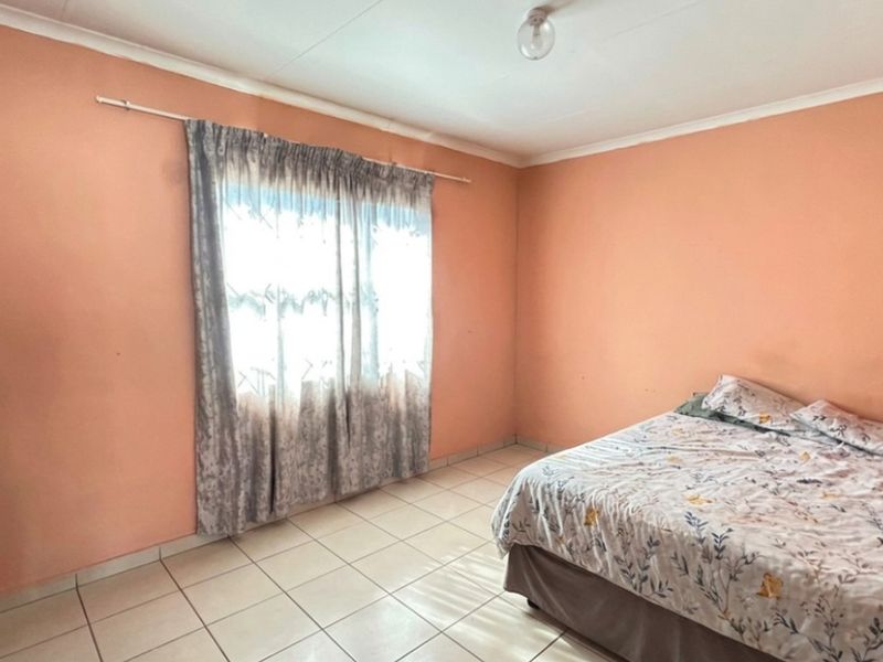A bedroom featuring tiled flooring and a simple ceiling light fixture, offering a blank canvas for potential cosmetic updates and interior design improvements.