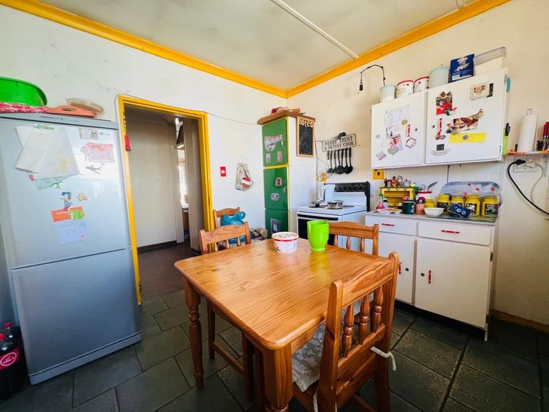 A dated kitchen featuring tiled flooring, built-in cabinetry, and a freestanding stove, offering significant potential for modernization and renovation.