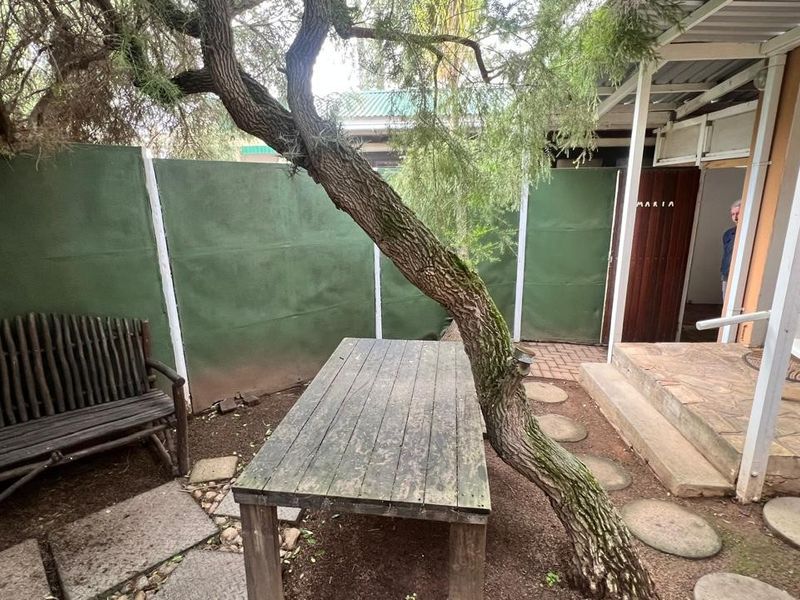A covered outdoor patio area featuring brick paving and direct access to the main dwelling, providing a shaded space for outdoor relaxation.