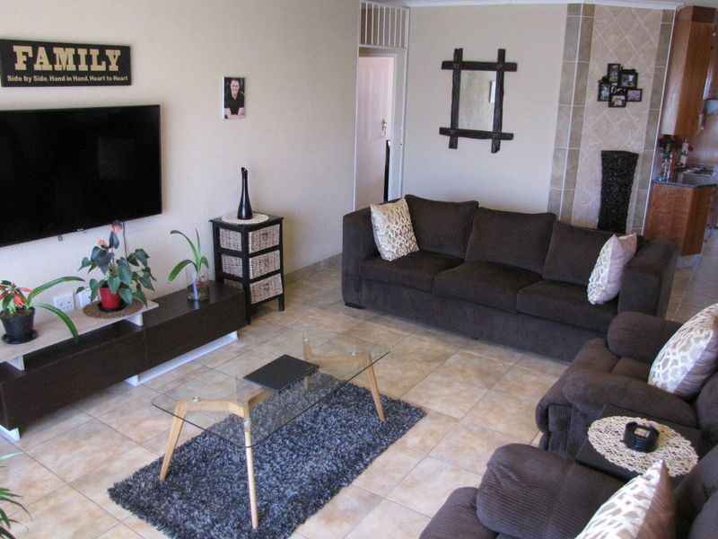 A living room featuring tiled flooring and a tiled fireplace surround, providing a functional and neutral space for relaxation.
