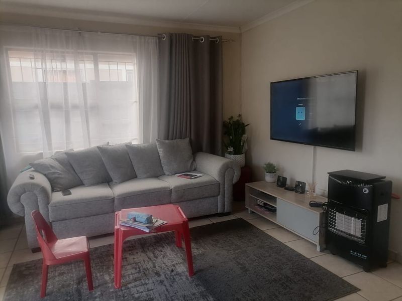 A functional living room featuring tiled flooring and neutral wall finishes, providing a comfortable and practical space for relaxation.