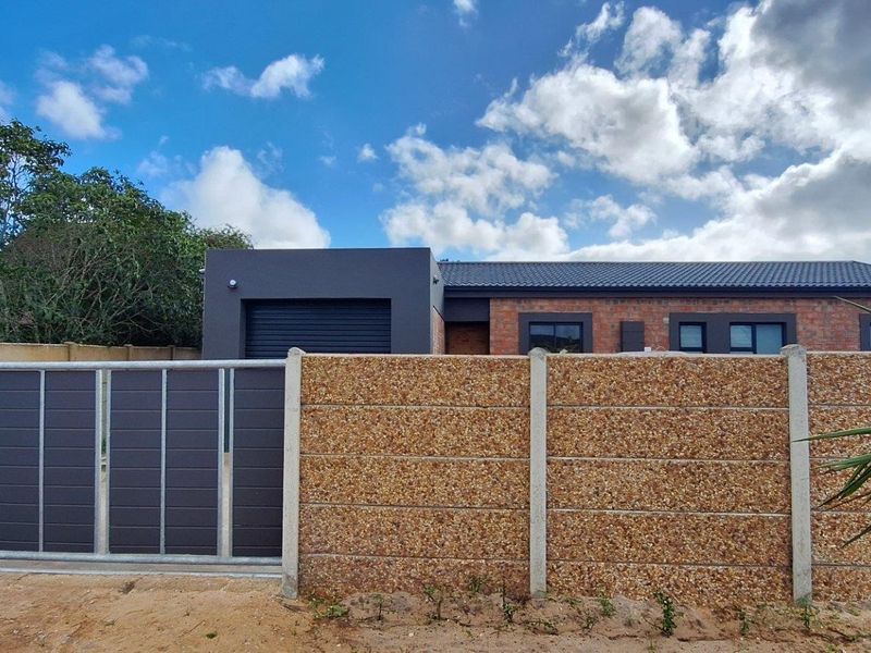 Front view of a modern brick house featuring a secure sliding gate, precast boundary wall, and a tiled roof.