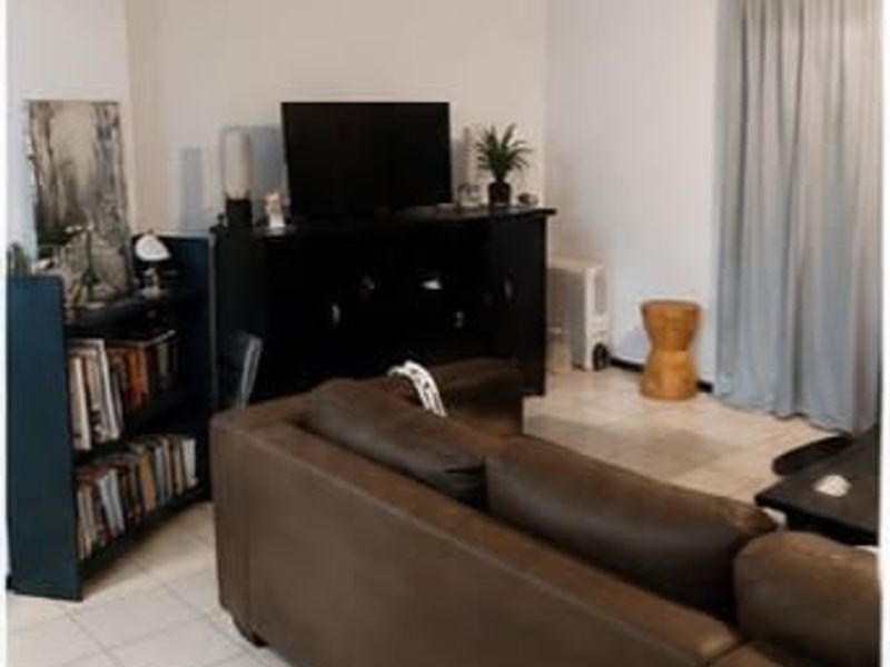 A living room area featuring tiled flooring and neutral wall finishes, providing a functional space for relaxation.