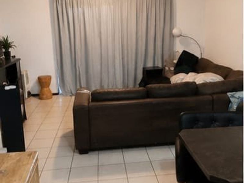 Open plan living area featuring tiled flooring and a large sliding glass door providing access to the exterior.