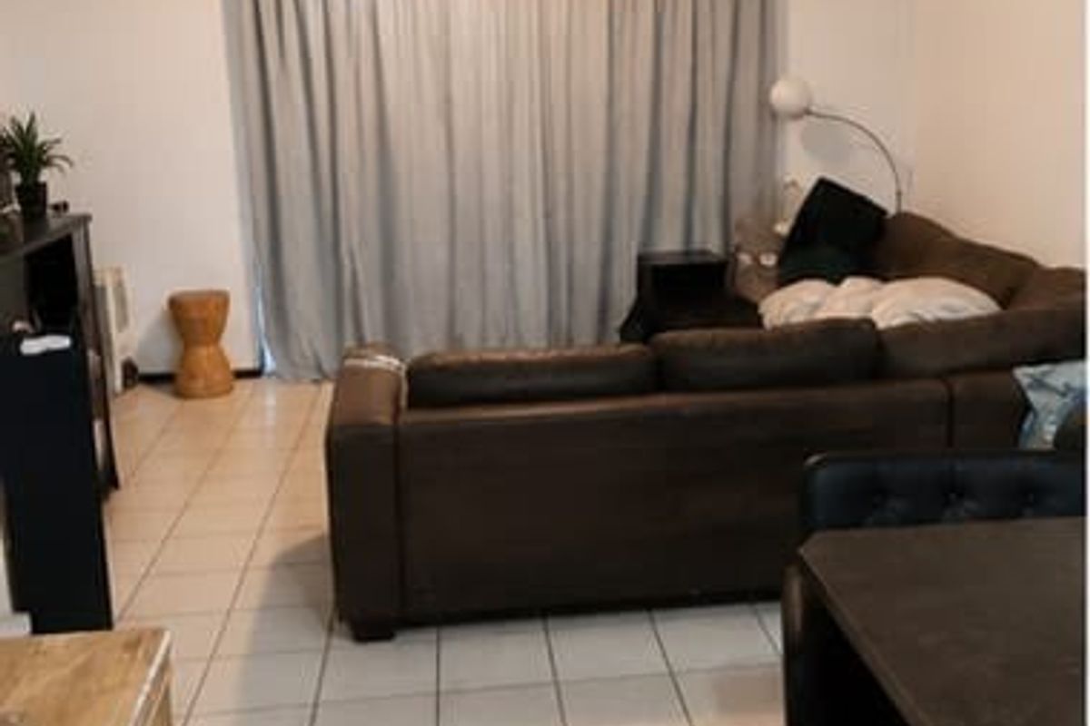 Open plan living area featuring tiled flooring and a large sliding glass door providing access to the exterior.