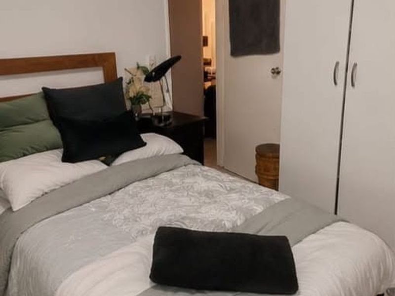 A bedroom featuring a built-in wardrobe and neutral wall finishes, providing a functional sleeping space.