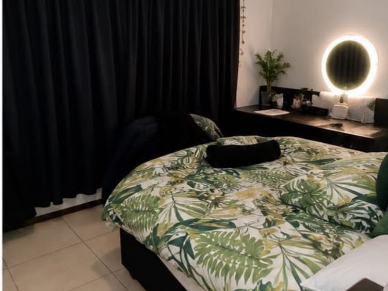 A bedroom featuring tiled flooring and a built-in vanity area with integrated lighting.