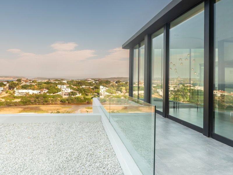 Modern balcony featuring a glass balustrade, large format tiling, and expansive floor-to-ceiling sliding doors with panoramic views.