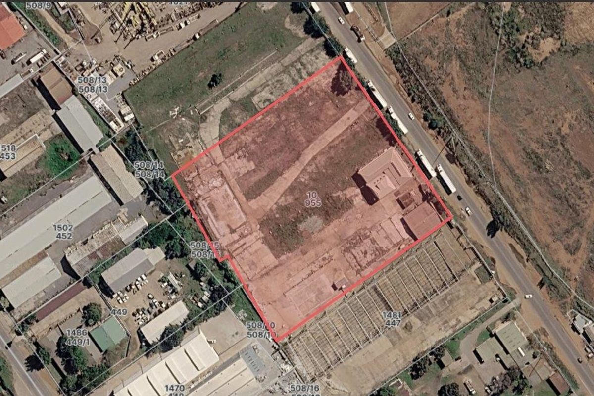 Aerial view of a commercial industrial plot with existing building foundations and site access.