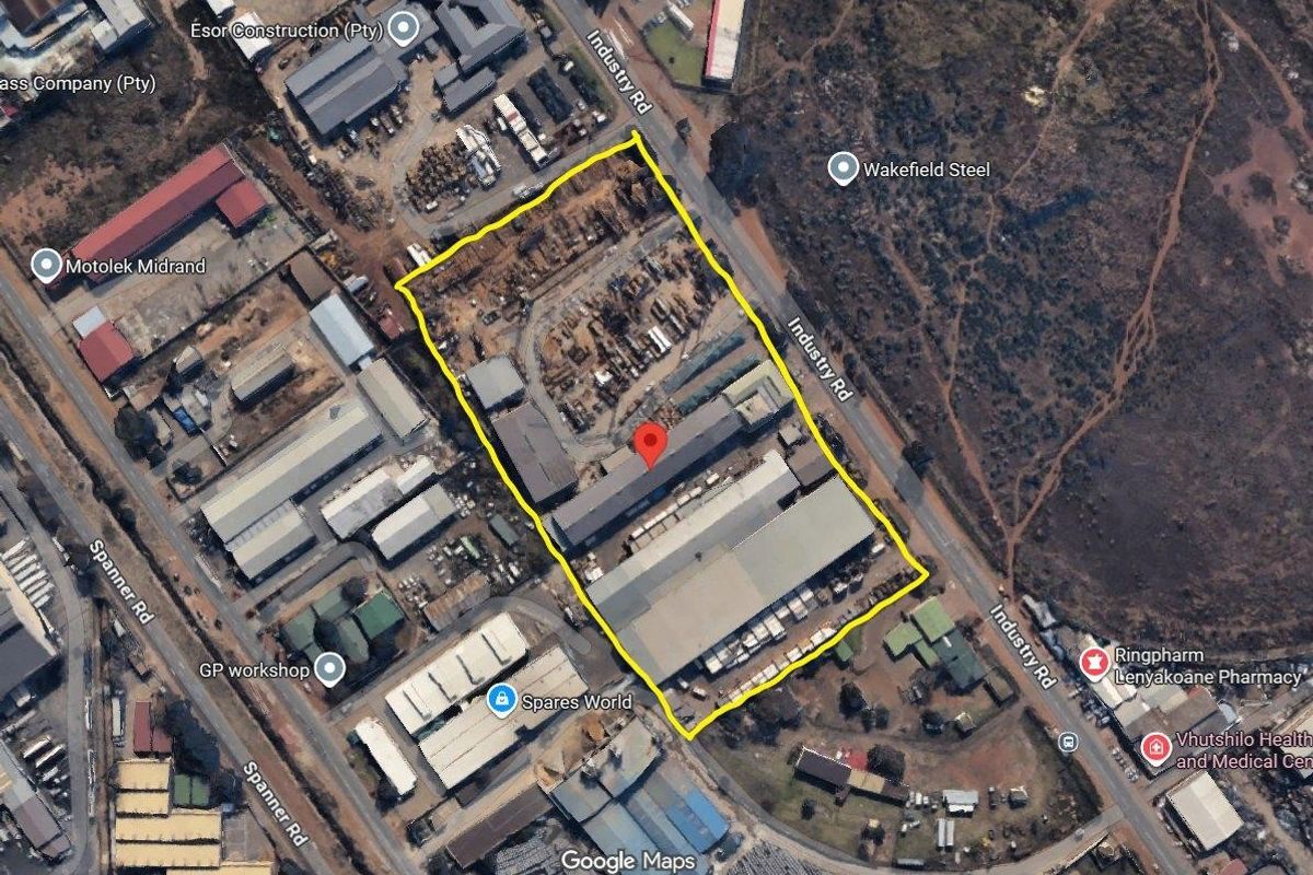 Aerial view of a commercial industrial property featuring multiple warehouse structures, a large yard area, and direct access from Industry Road.