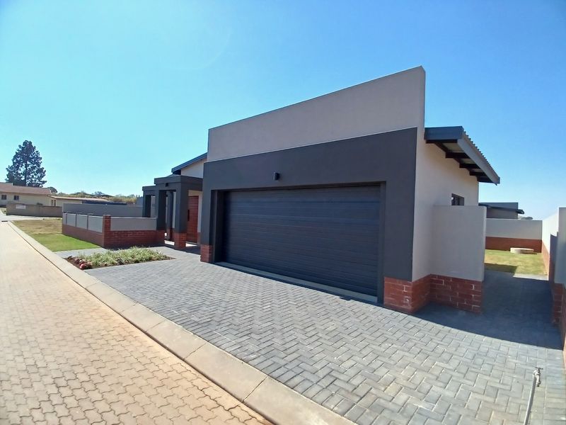 Modern residential property featuring a clean facade, double garage, and paved driveway in a well-maintained estate setting.