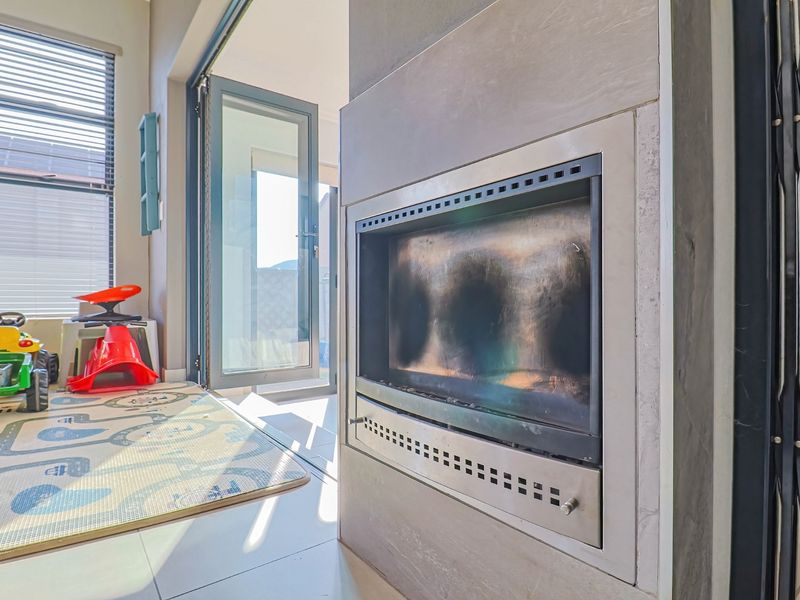 Living area featuring a built-in fireplace with a modern surround and direct access to the outdoor patio through aluminium sliding doors.