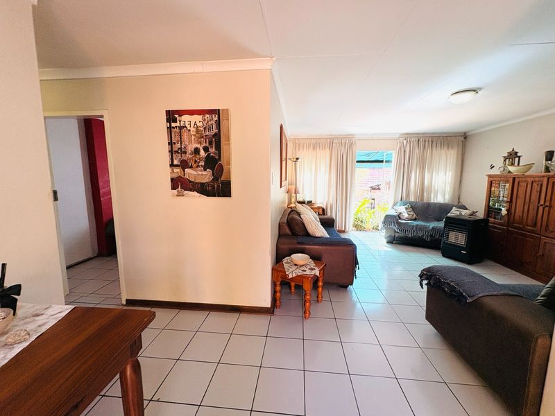 Spacious living area featuring neutral tiled flooring and direct access to the outdoor patio through sliding glass doors.
