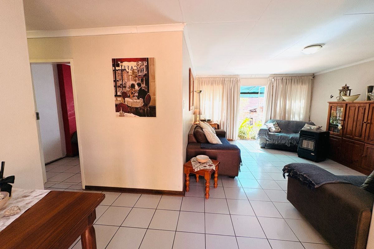 Spacious living area featuring neutral tiled flooring and direct access to the outdoor patio through sliding glass doors.