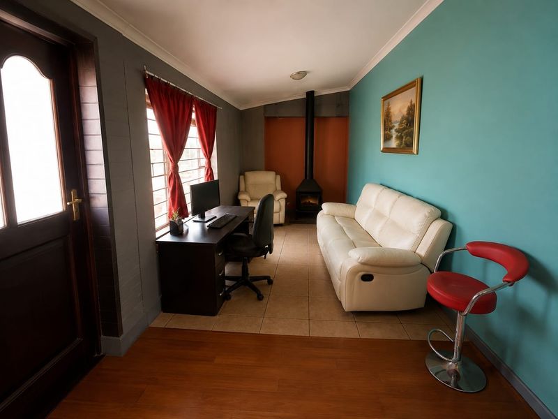 A multi-functional living space featuring a freestanding fireplace, tiled and laminate flooring, and large windows with security bars.