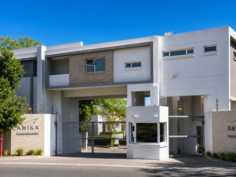 Modern residential complex entrance featuring a secure gated access point, guard house, and contemporary architectural facade with stone cladding accents.
