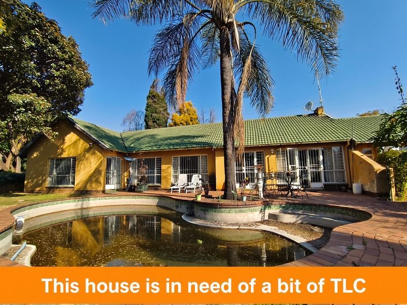 Rear exterior view of the house featuring a swimming pool, paved patio area, and traditional tiled roof architecture.
