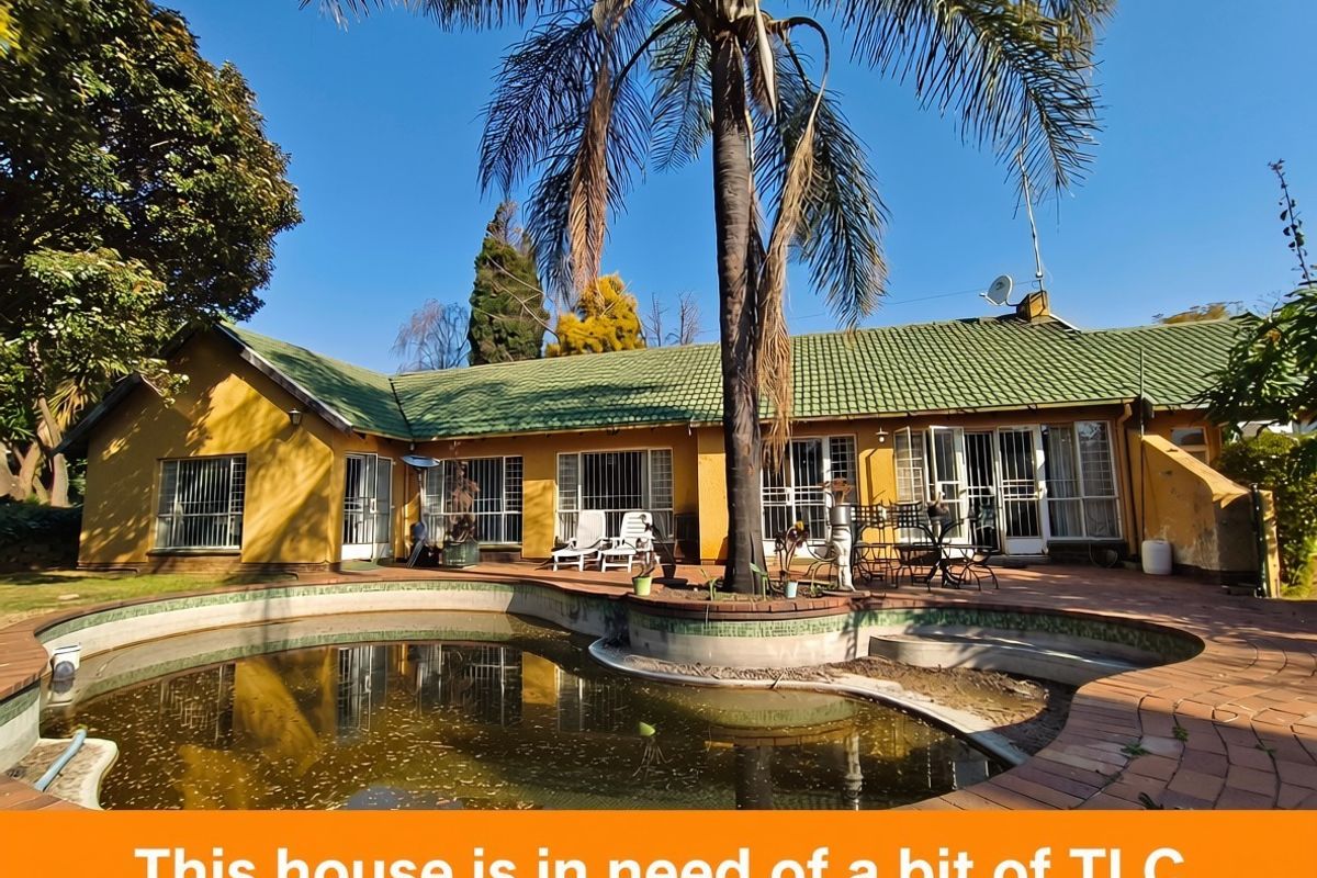 Rear exterior view of the house featuring a swimming pool, paved patio area, and traditional tiled roof architecture.